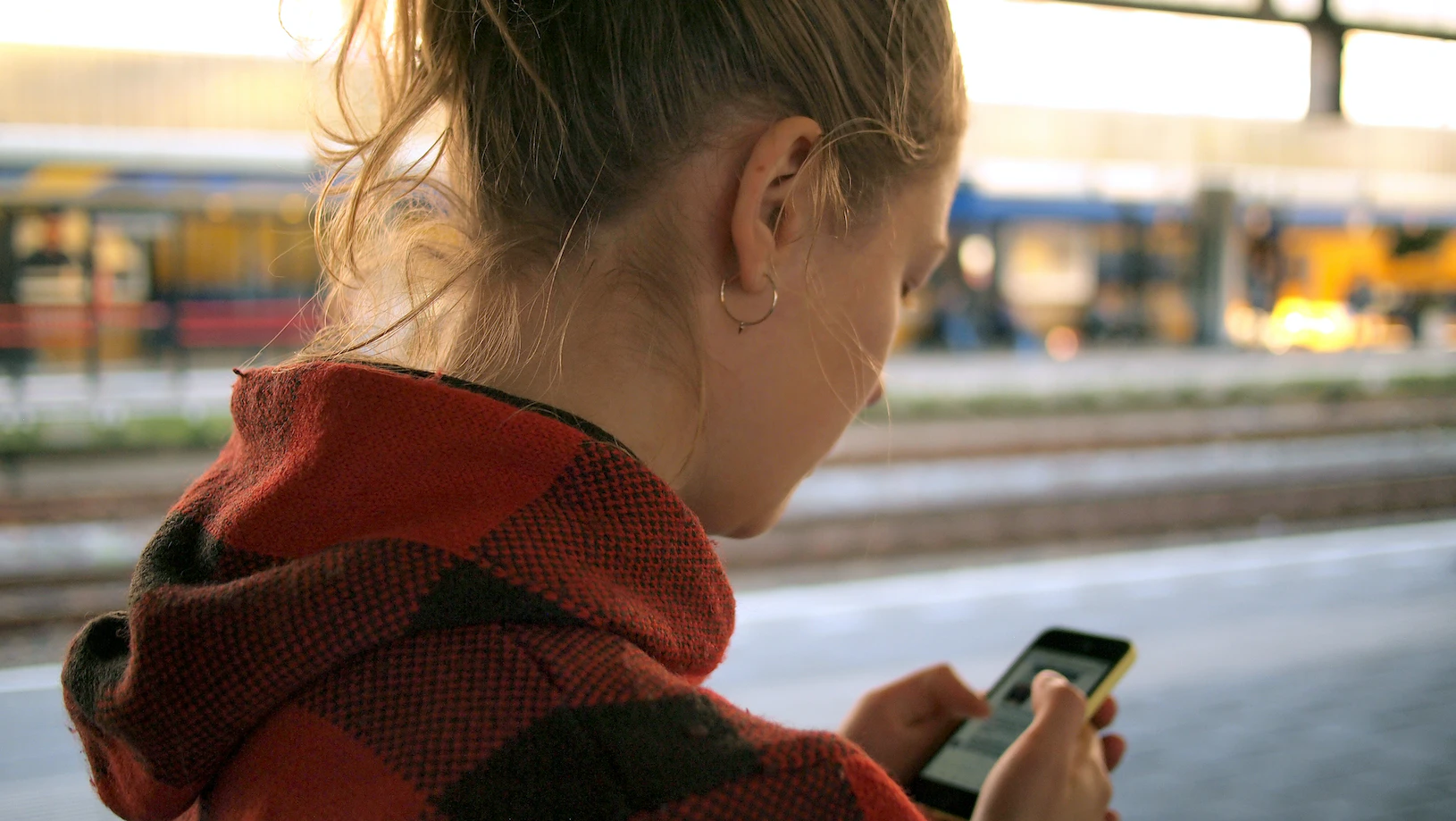 Frau am Handy, die möglicherweise kostenpflichtige Social Media Tools nutzt.